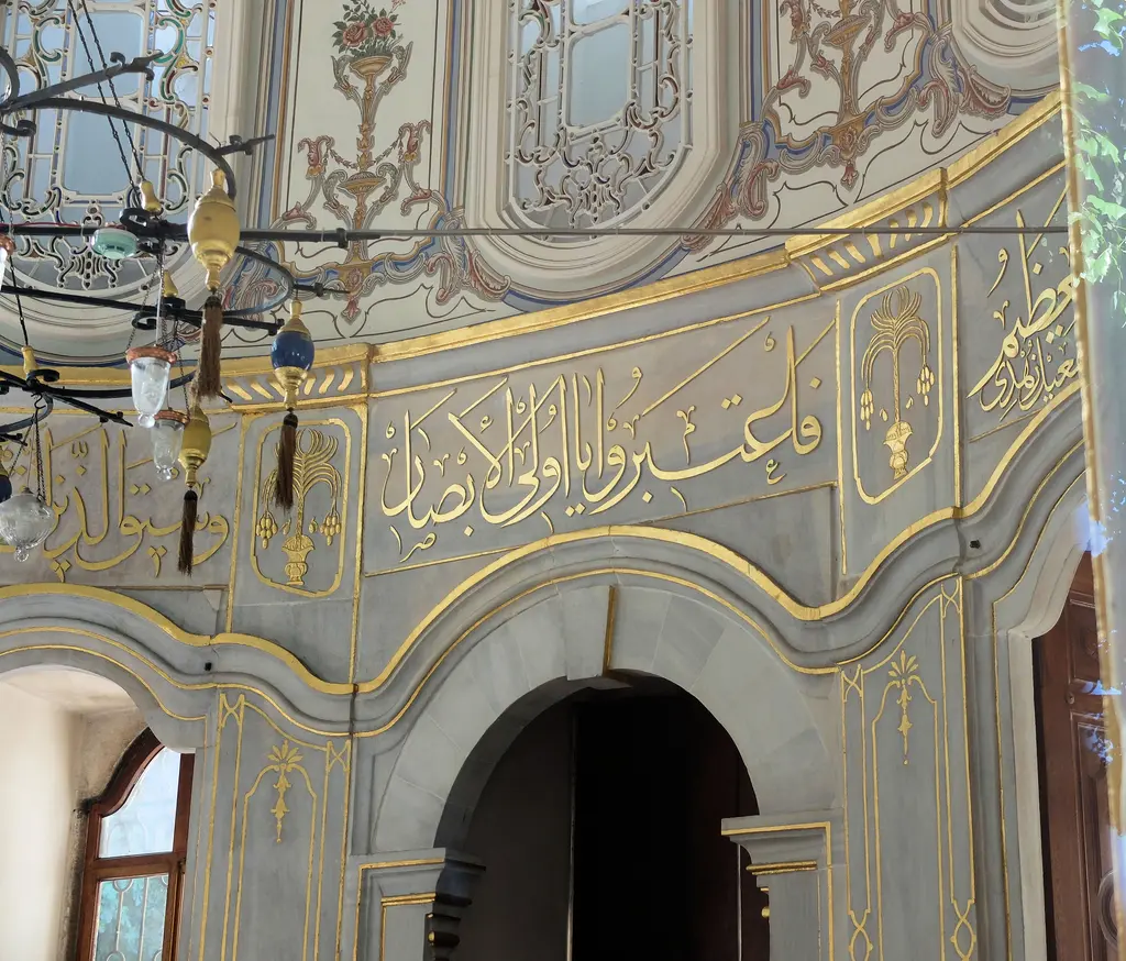 Şah Sultan Türbesi'nin içinde yazı kuşağı; gri zemin üzerinde altın yaldızlı celî sülüs yazı, çiçekli kalem işi ve kemer.