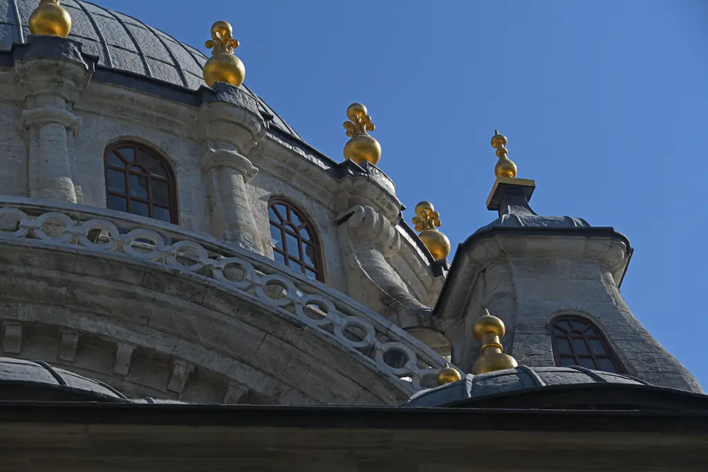 Nusretiye Camii'nin kubbe kasnağından ayrıntı; kemerli pencereler, kıvrımlı barok silmeler ve kenarlara dizili altın yaldızlı küçük alemler.