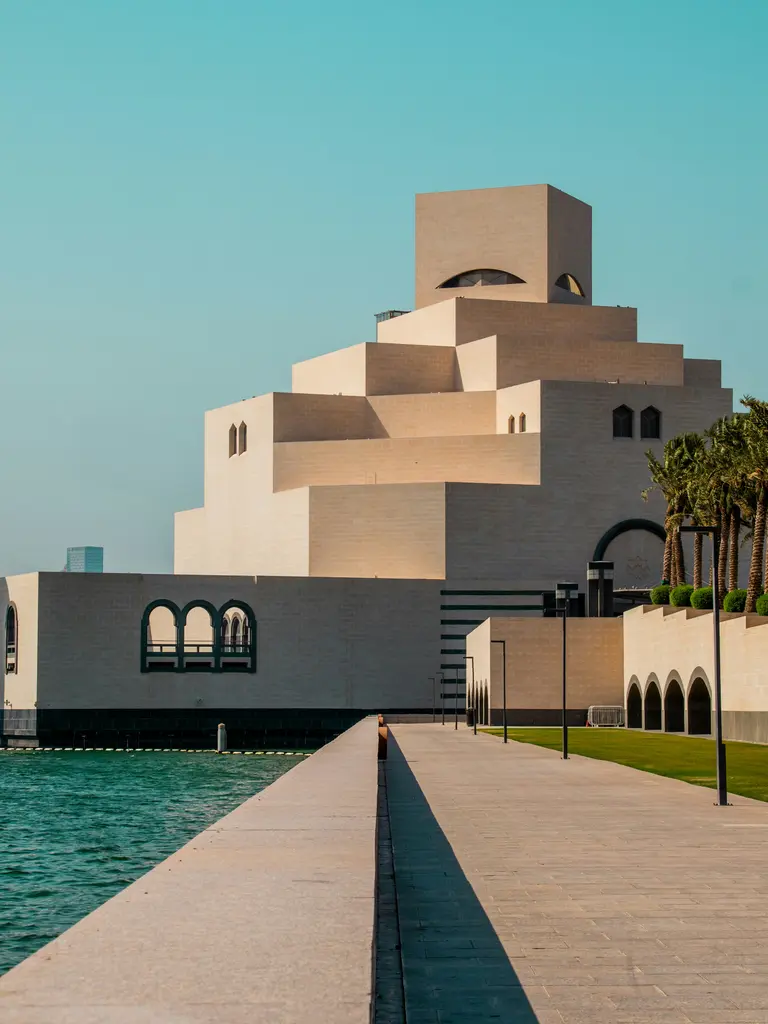 Doha'da İslam Sanatları Müzesi; üst üste binen küp biçimli beyaz kütleleri, gölgeli girintileri ve önündeki geniş merdiven.