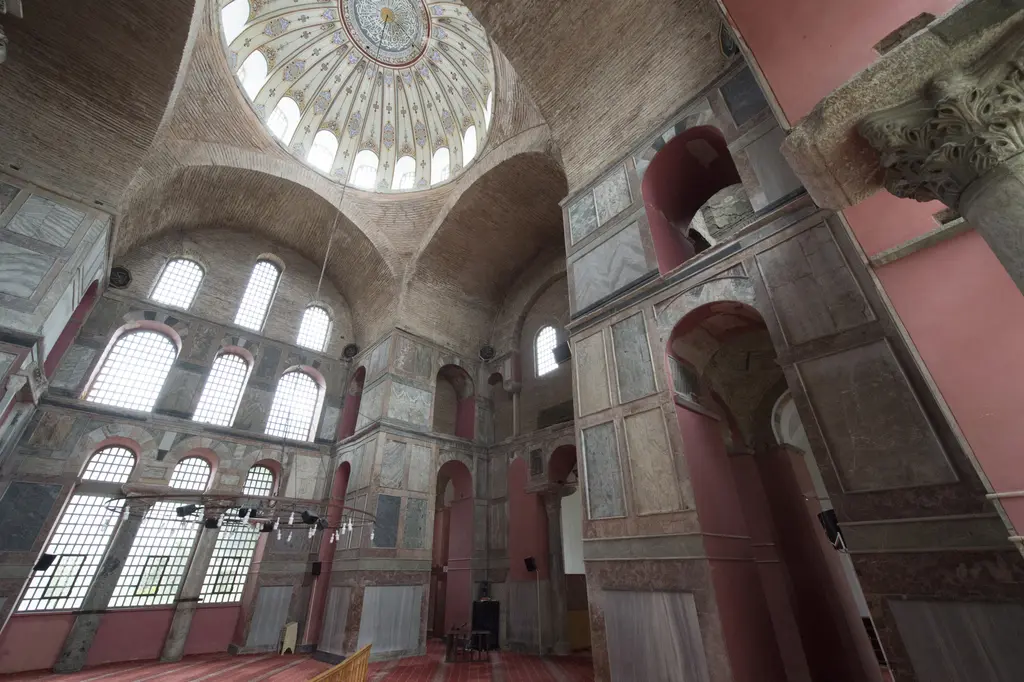 Kalenderhane Camii'nde harimin köşesinden yukarı bakış; bezemeli kubbe, tuğla tonozlar, iki sıra pencere ve gri yeşil damarlı mermer ayaklar.