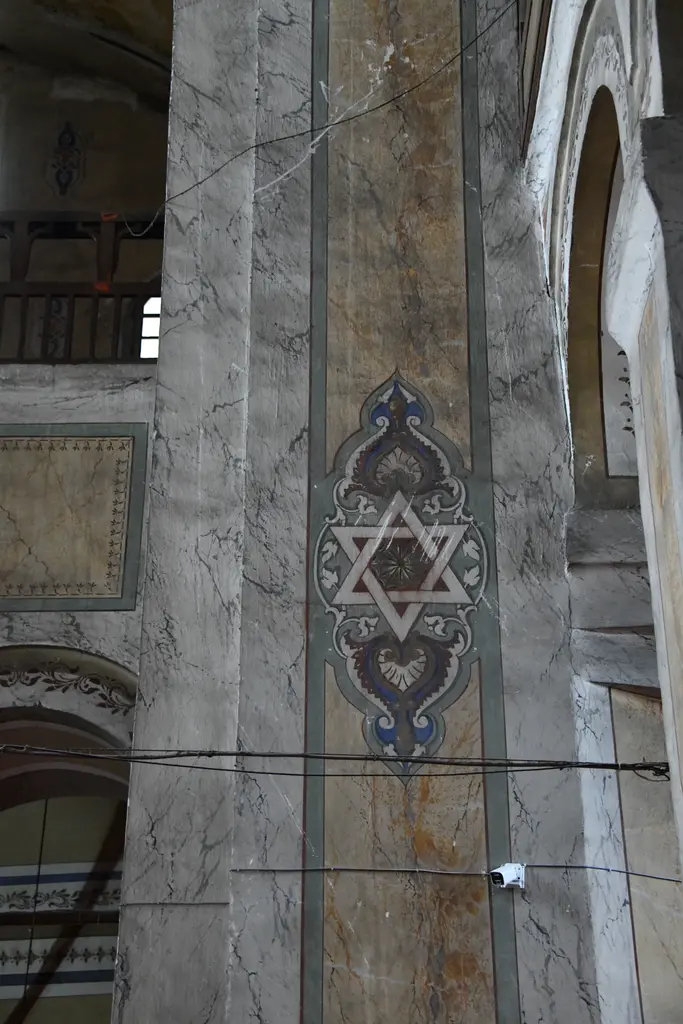 Gül Camii'nde paye yüzeyindeki madalyon; mermer taklidi boyamanın üstünde mavi rumi kartuş içinde büyük bir altı köşeli yıldız, kadrajı kesen kablolar.