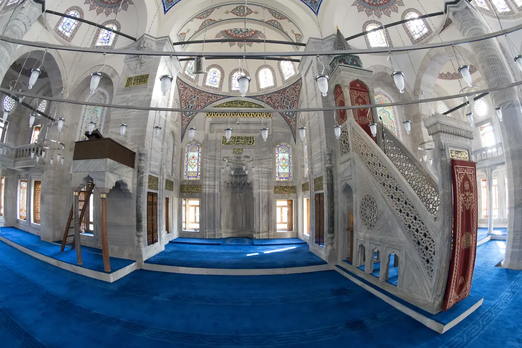 Azapkapı Sokullu Mehmed Paşa Camii'nde harim; sağda oymalı mermer minber, ortada mihrap duvarı, mavi halı ve avize çemberleri.