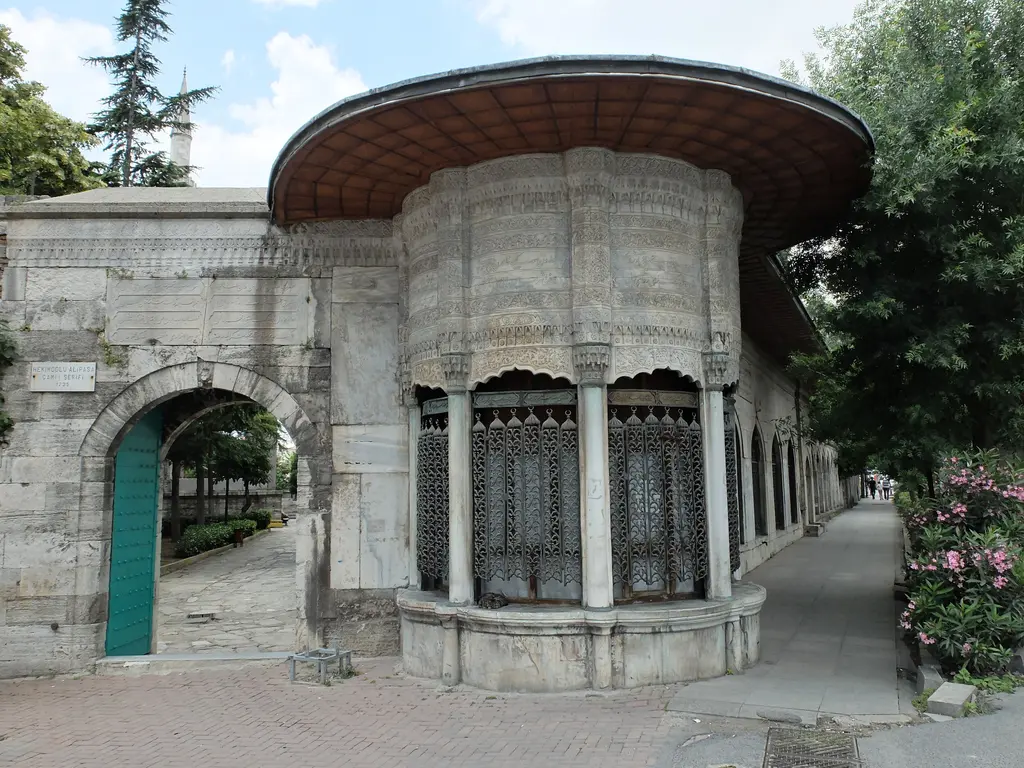 Külliyenin köşesindeki sebil; yuvarlak dilimli mermer gövde, tunç şebekeli pencereler, üstte kurşun kaplı saçak ve yanında avlu kapısı.
