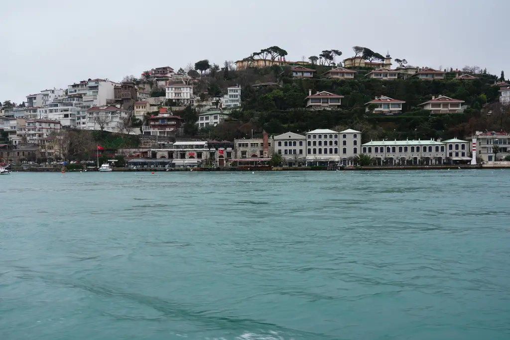 Boğaz'dan Çengelköy; kıyı boyunca beyaz yalılar, ağaçlıklı sırt ve tepede kiremit çatılı villalar.