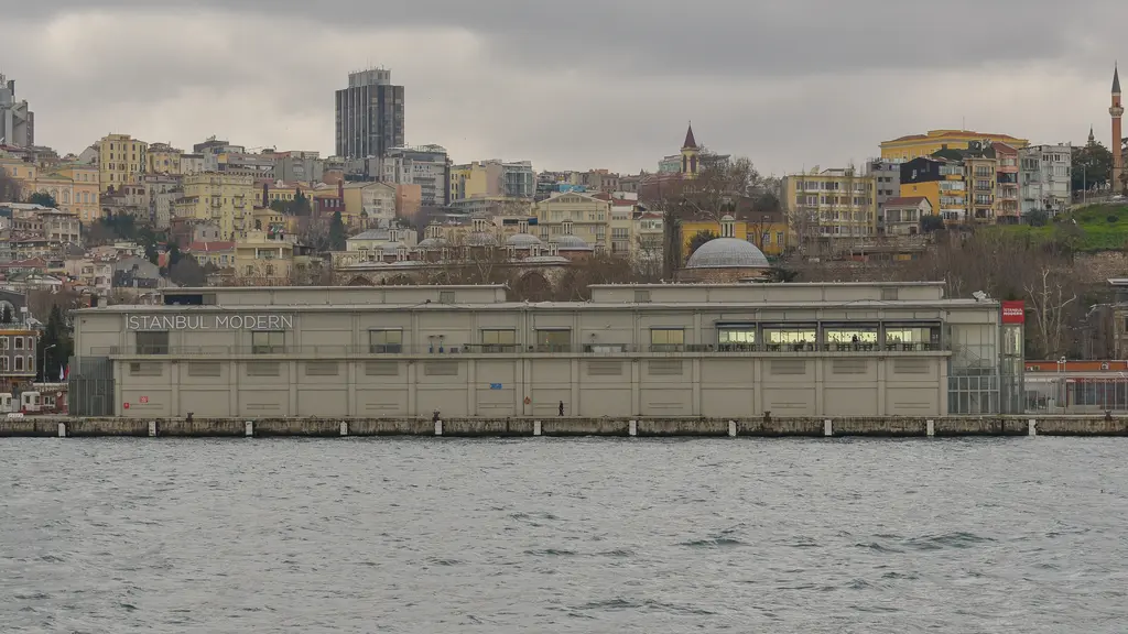 Denizden İstanbul Modern'in eski binası; kıyıda alçak, uzun gri antrepo ve arkasında Beyoğlu yamacının binaları.