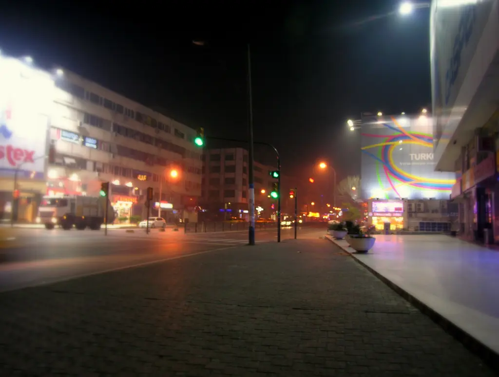 Gece Bağdat Caddesi; ışıklı mağaza vitrinleri, reklam panoları, trafik ışıkları ve geniş kaldırım.