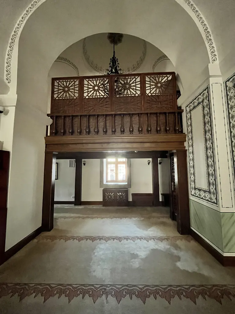 Koca Mustafa Paşa Camii'nde ahşap mahfil; oyma kafesli korkuluk ve dikmelerle taşınan asma kat, altında aydınlık bir geçit, iki yanda beyaz kemerli duvarlar ve yeşil etek panoları.