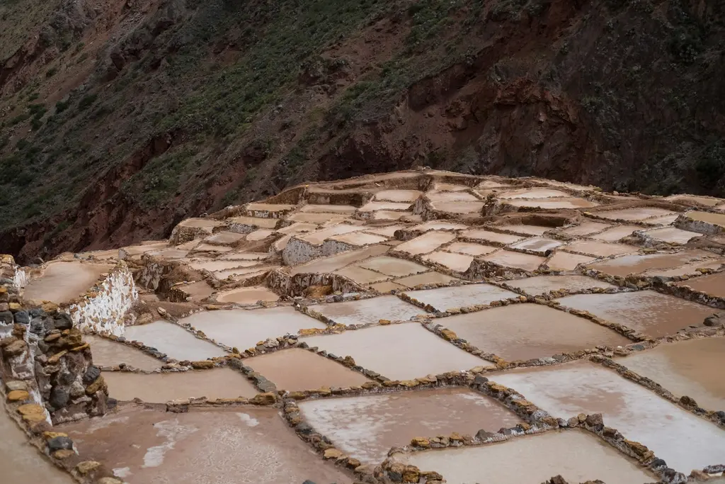 Kutsal Vadi'de manzara; Urubamba Nehri boyunca uzanan yeşil tarım terasları ve çevreleyen dik dağlar.