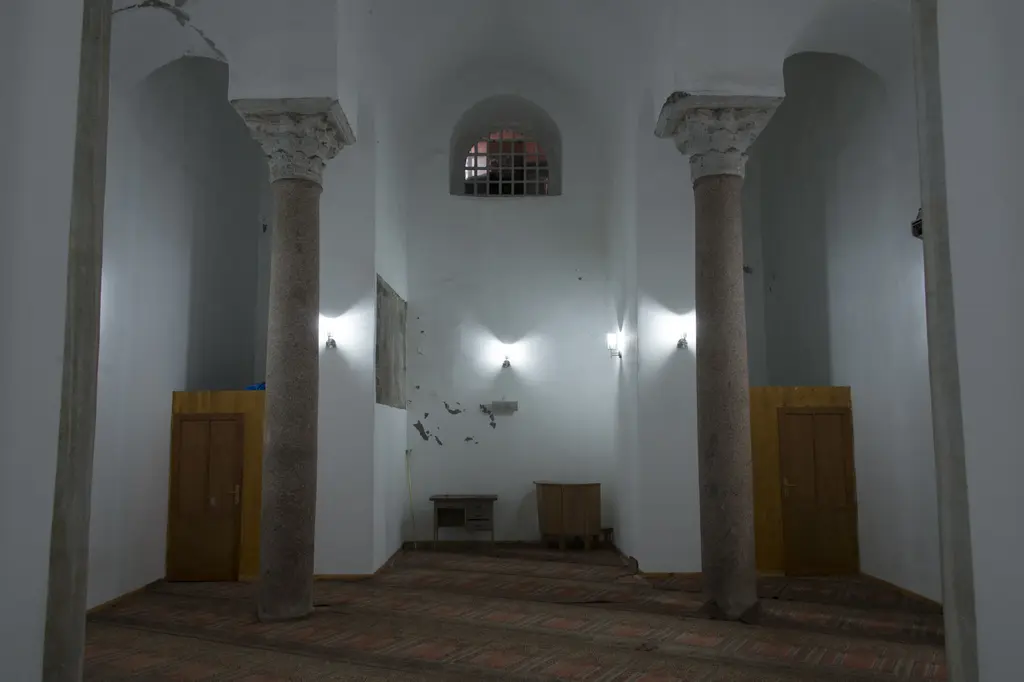 Bodrum Camii'nin alt yapısında rotundanın eğrisi; iki granit sütun üstünde devşirme mermer başlıklar, arkada yarım daire dönen duvar, iki sarı ahşap kapı ve dökülmüş sıva.