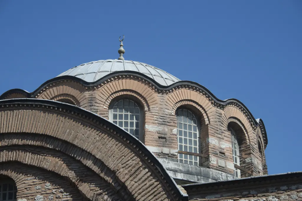 Kalenderhane Camii'nin kubbesi; kemerli pencereli dalgalı kasnak, kurşun kaplı kubbe, hilalli alem ve önde kat kat tuğla kemerler.