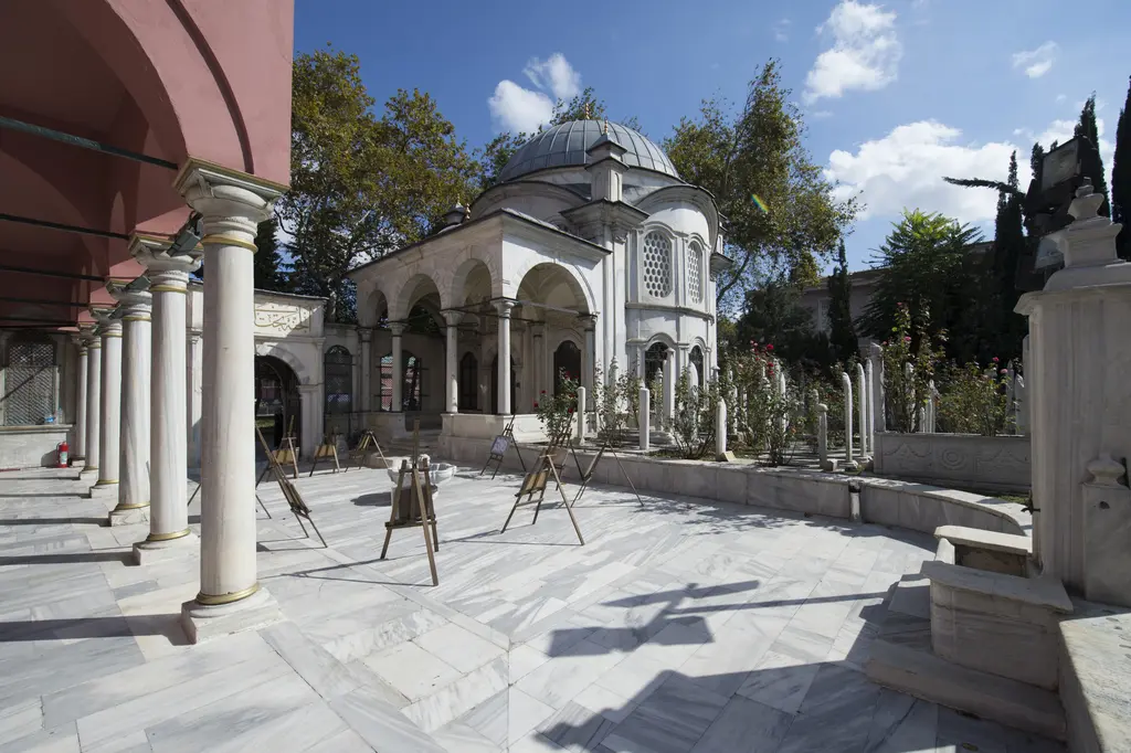 Şah Sultan Külliyesi'nde avludan türbe; pembe kemerin altından görülen sütunlu revak, kubbe ve mermer döşeme.