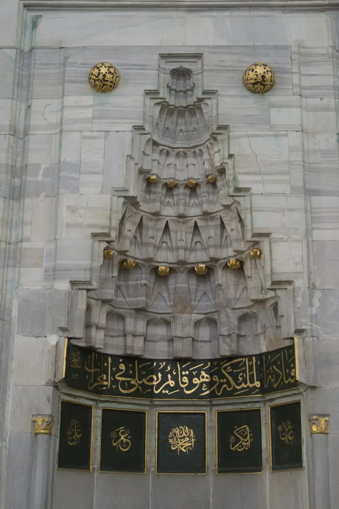 Gazi Atik Ali Paşa Camii'nin mihrap kavsarası; kademeli mukarnas, yaldızlı süsler, altta siyah zemin üzerine altın yazı şeridi.