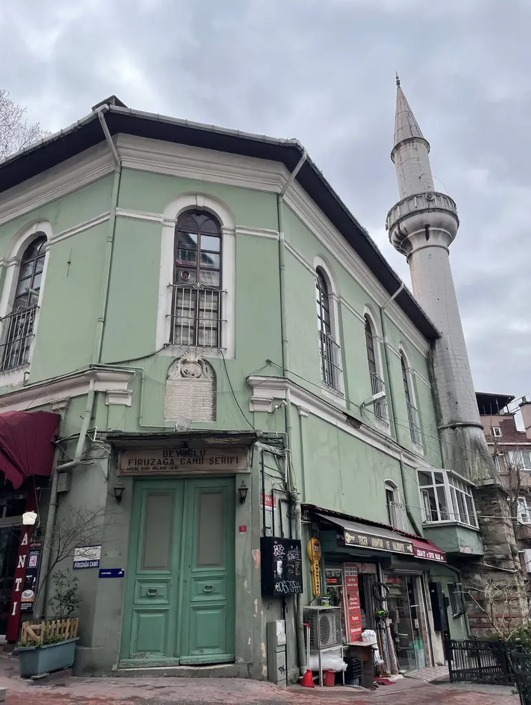 Firuzağa Camii; yeşil boyalı cephe, kemerli pencereler ve yanında yükselen minare.