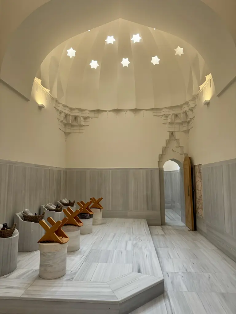 Çinili Hamam'ın sıcaklığı; yıldız biçimli aydınlık gözleri açılmış kubbe, mukarnaslı geçiş, mermer kaplı duvarlar ve nalın konmuş mermer sehpalar.
