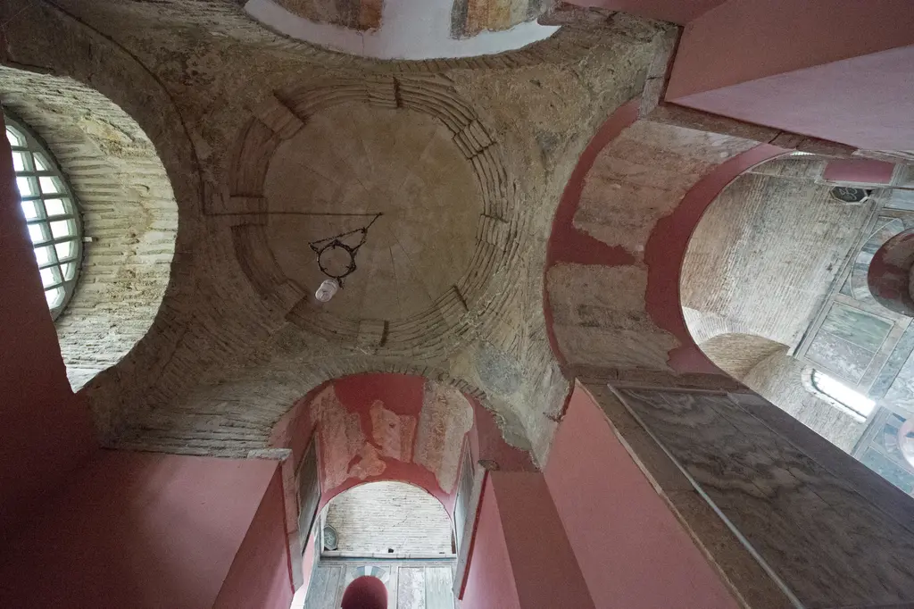 Kalenderhane Camii'nde köşe hücresinin küçük kubbesi; halka halka tuğla dizilimi, ortadan sarkan lamba, yuvarlak pencere ve pembe kemerler.