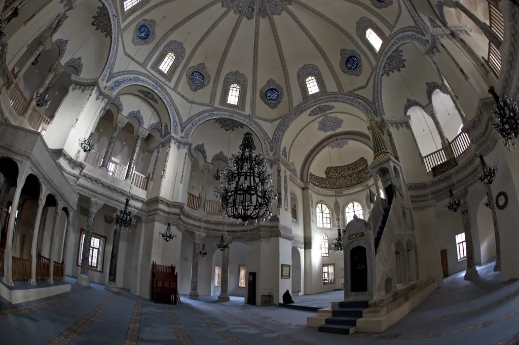 Küçük Ayasofya Camii'nin harimi geniş açıyla; ortada kaburgalı kubbe ile büyük ferforje avize, sağda yeşil altın külahlı beyaz mermer minber, çevrede ahşap korkuluklu üst galeriler.