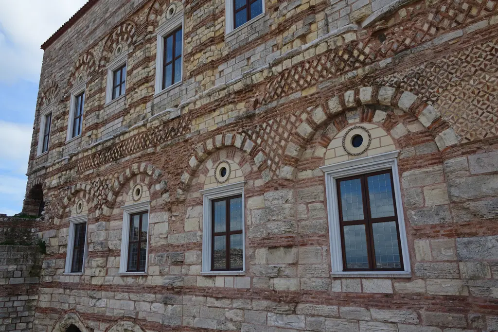 Tekfur Sarayı'nın cephesinde duvar detayı; kırmızı tuğla ile açık renk taşın baklava, zikzak ve yıldız desenleri oluşturduğu örgü ve kemerli pencereler.