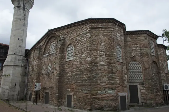 Fatih'te Atik Mustafa Paşa Camii'nin apsis cephesi; çok yüzlü tuğla ve taş duvarlar, kemerli şebekeli pencereler, dişli tuğla saçak ve solda yükselen taş minare.