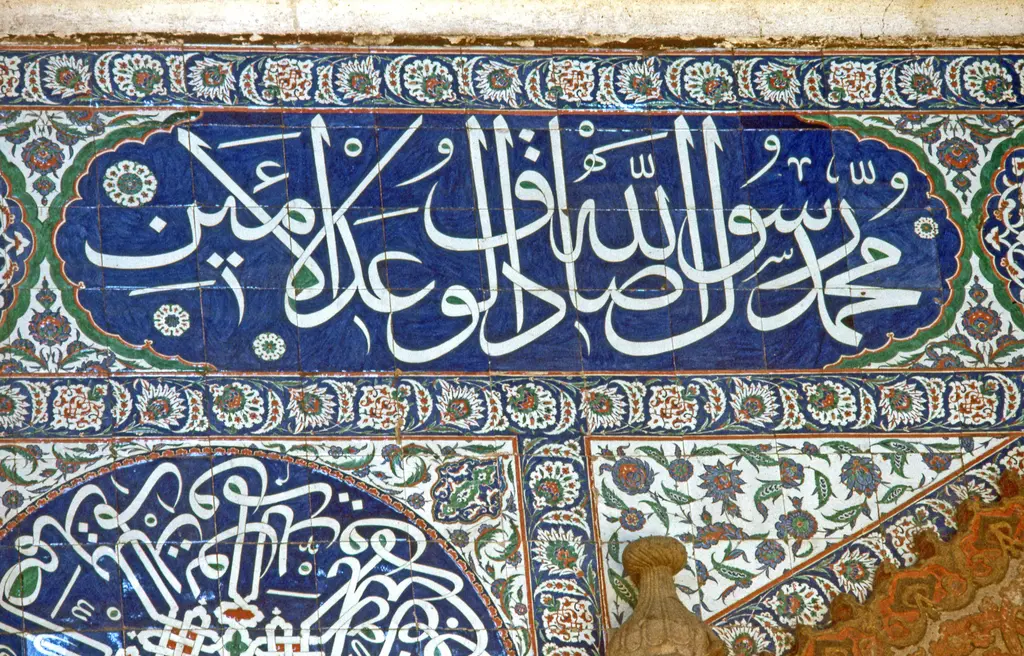 Sokullu Mehmed Paşa Camii'nde hat kuşağı; lacivert zemin üzerine beyaz iri harfler, üstünde bitkisel çini bordür ve altta yaldızlı bezeme.