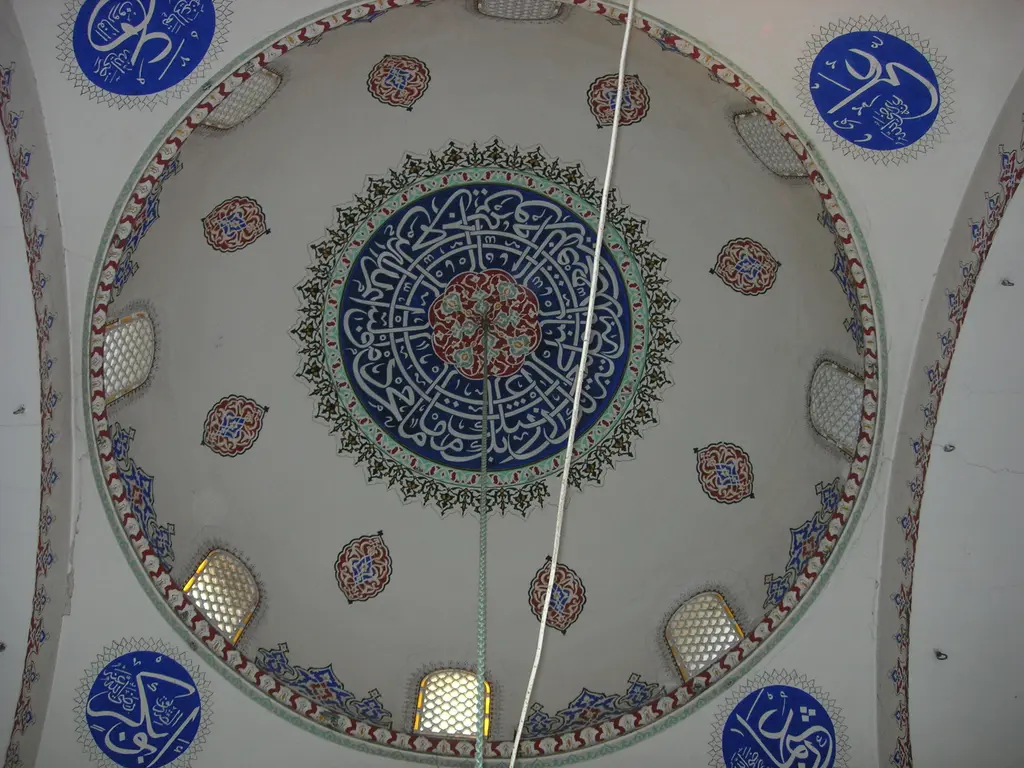 Koca Mustafa Paşa Camii'nin kubbesine dik yukarı bakış; merkezde mavi kırmızı çiçekli büyük göbek, çevresinde çiçek bordürü, etekte mavi zeminli yuvarlak hat madalyonları.