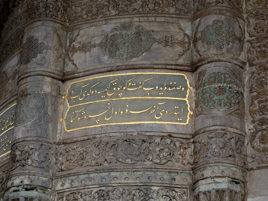 Sebil köşesinde kitabe; yuvarlak mermer yüzeye işlenmiş altın yaldızlı iki satır yazı, çevresinde kabartma ve çini parçaları.