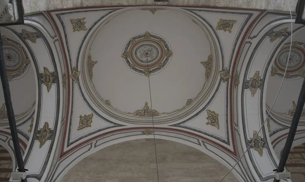 Laleli Camii'nde revak örtüsü; kalem işiyle bezenmiş kubbe ve tonozlar, ortada rozet motifi ve kemerlerin üstünde ince silmeler.