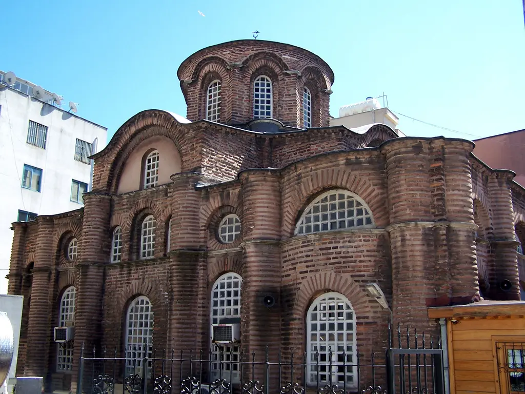 Fatih'te Bodrum Camii'ne kuzeybatıdan bakış; tuğla ve taş örgülü gövdeyi dikey bölen yarım daire payandalar, üstte kemerli bitişler ve ortada çok pencereli kubbe kasnağı.