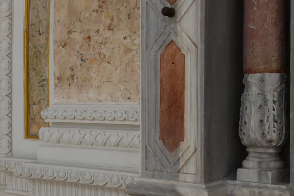 Ortaköy Camii'nde mihrap çevresinden ayrıntı; beyaz mermer yüzeyler, pembe taş kaplama ve yanda süslü başlıklı sütun.