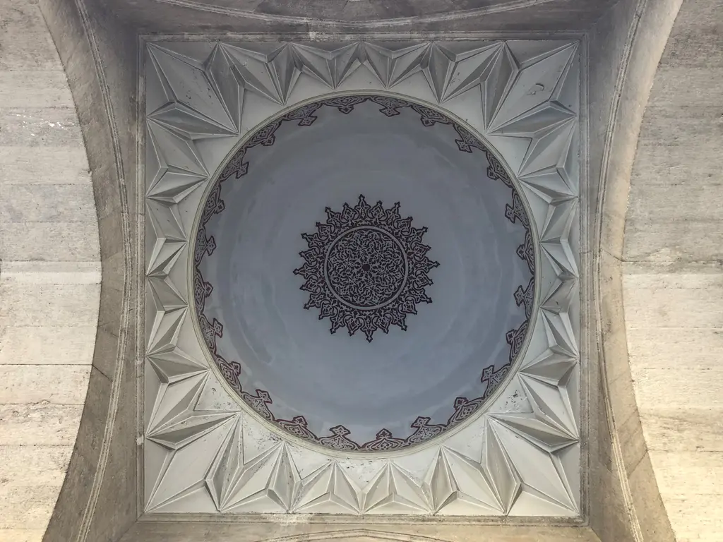 Şişli Camii'nin revakındaki kubbelerden biri; beyaz sıvalı kubbe, ortada koyu renkli rozet, kenarda bordür ve taş kemerler.