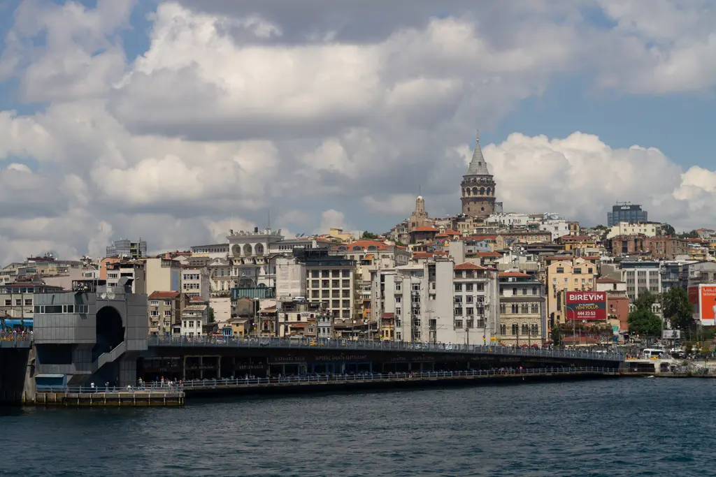 Haliç'ten Galata Köprüsü ve Karaköy; köprünün uzun gövdesi, kıyıdaki binalar ve yamacın tepesinde Galata Kulesi.