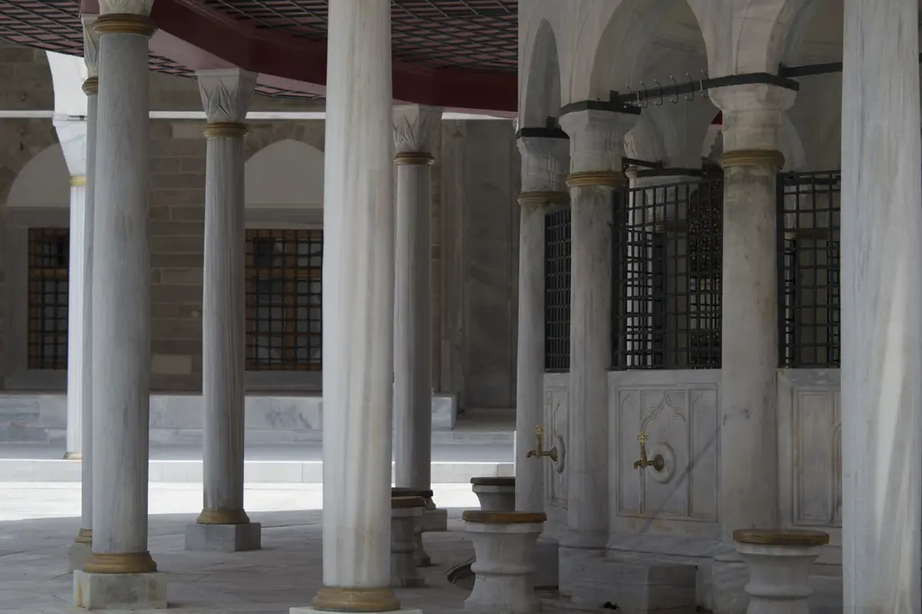 Mihrimah Sultan Camii avlusundaki şadırvan yakından; ince sütunlar, üstünde saçak, çevresini dolanan musluk sırası ve mermer tekne.