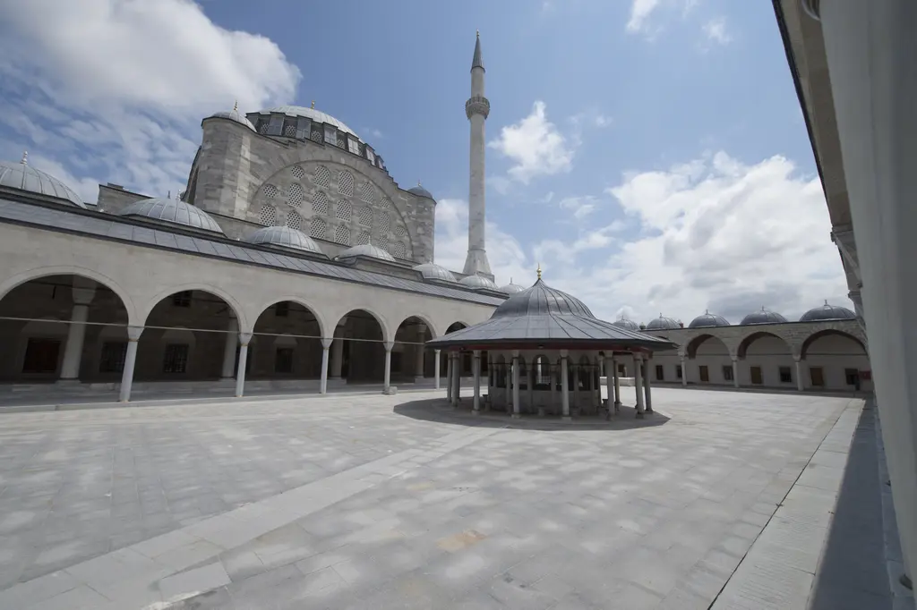 Mihrimah Sultan Camii'nin avlusu kuzeyden; revaklı galeriler, ortada kubbeli şadırvan, arkada caminin gövdesi ve tek minare.