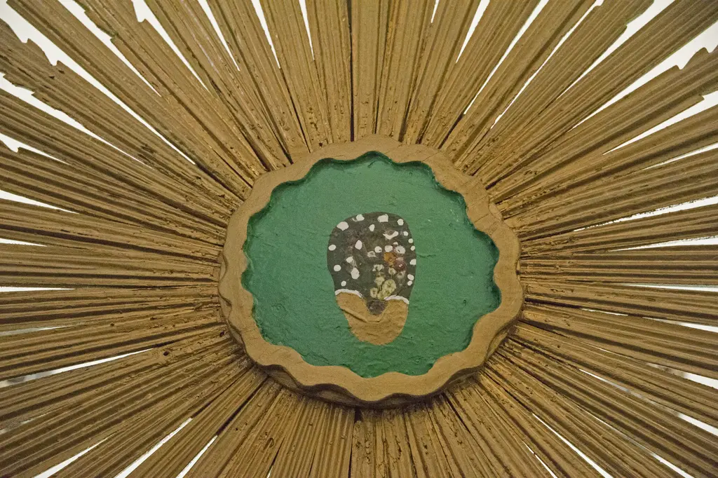 Atik Mustafa Paşa Camii'nde yaldızlı Mahmud güneşinin yakın planı; merkezde yeşil zeminli dalgalı madalyon, çevresinde her yöne açılan uzun altın yaldızlı ışınlar.