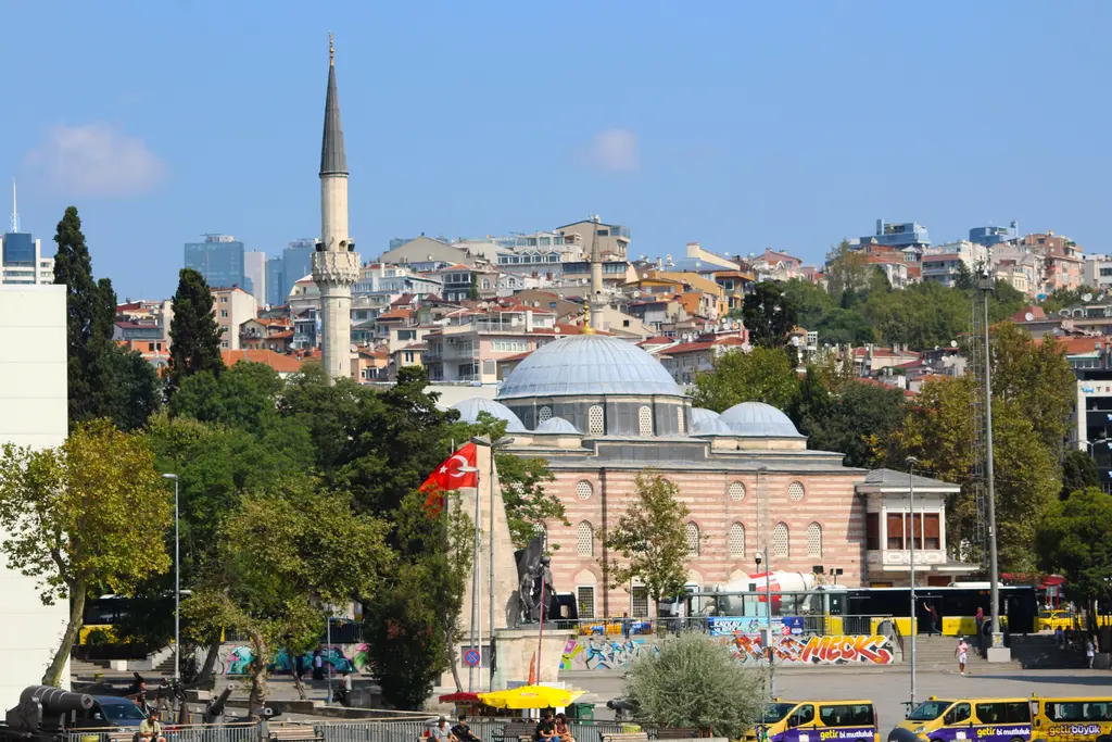 Beşiktaş'ta Sinan Paşa Camii; kurşun kaplı kubbe, tek minare, çevresinde ağaçlar, önde meydan ve arkada yamaca yayılan binalar.