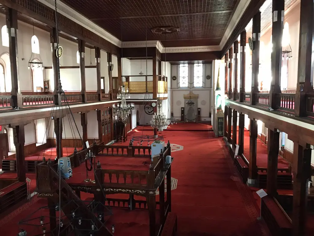Arap Camii'nde mahfiller; ahşap direklerin taşıdığı iki katlı galeriler, korkuluklar, kırmızı halı ve beyaz duvarlar.