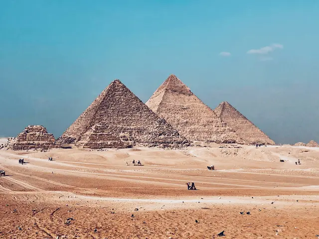 Giza'da piramitler; çölün kenarında yükselen üç büyük piramit ve önlerindeki kum düzlüğü.
