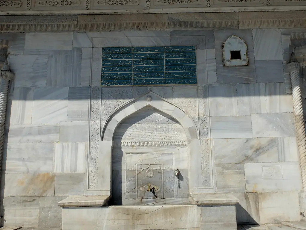 III. Ahmed Çeşmesi'nde çeşme nişi; sivri kemerli mermer niş, pirinç musluk, üstte yazı levhası.
