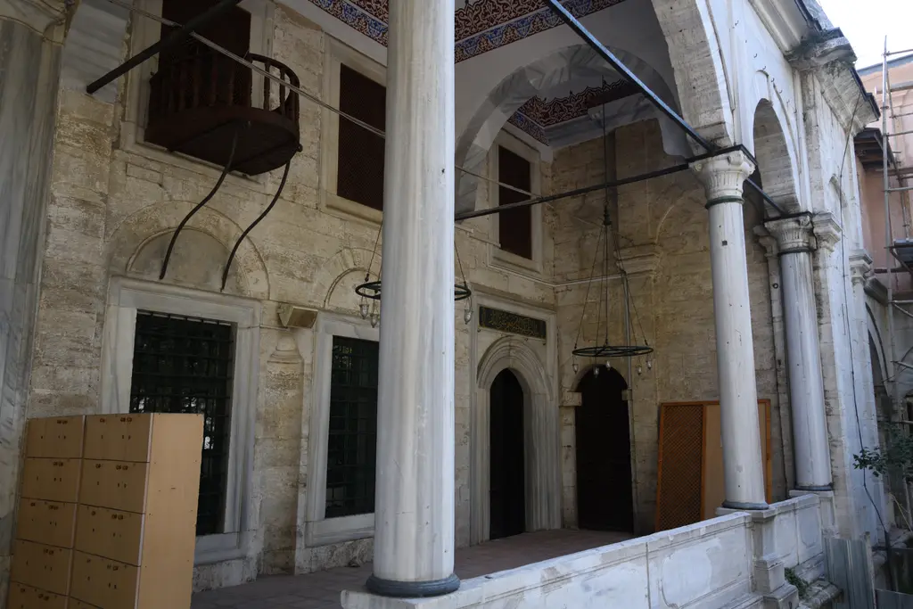 Selimiye Camii'nin girişi; mermer çerçeveli kapı, üstte yazılı kitabe, tavandan sarkan kandil ve yanlarda sütunlar.