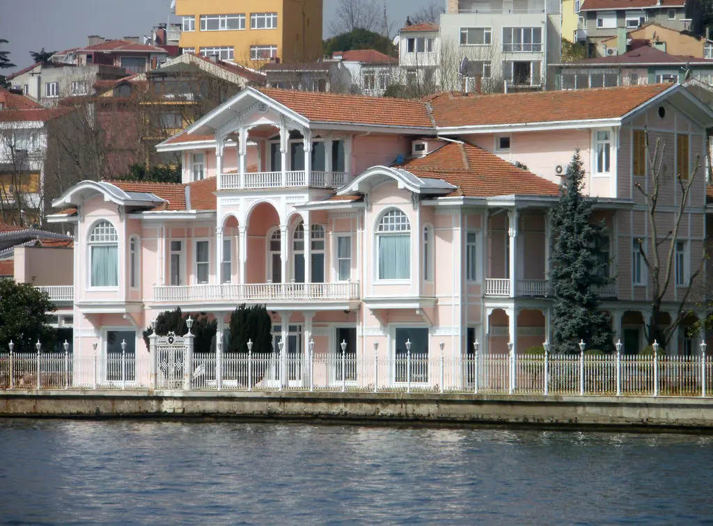 Şehzade Burhaneddin Efendi Yalısı; pembe cephe, beyaz süslemeler, kiremit çatı ve önde beyaz korkuluklu rıhtım.