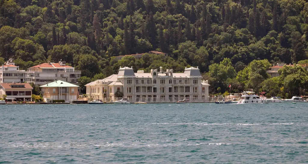 Bebek'te uzaktan Mısır Konsolosluğu; kıyıda beyaz yalı, çevresinde açık renkli binalar, arkada ağaçlık sırt ve önde Boğaz.