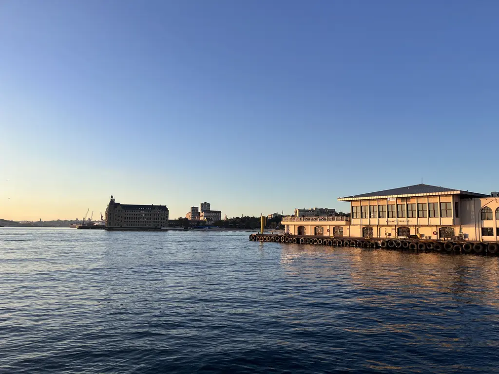 Gün batımında Haydarpaşa Garı; sakin deniz, kuleli gar binasının silueti ve sağda iskele yapısı.