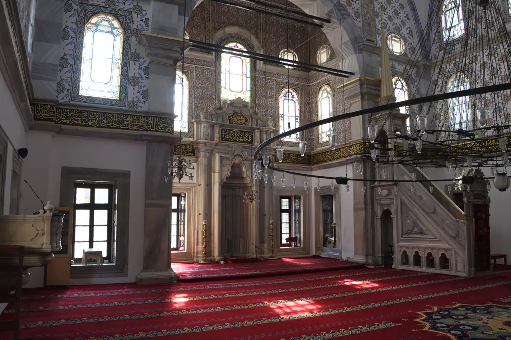 Selimiye Camii'nde mihrap ve minber; mermer mihrap nişi, yanında külahlı mermer minber ve kırmızı halı.