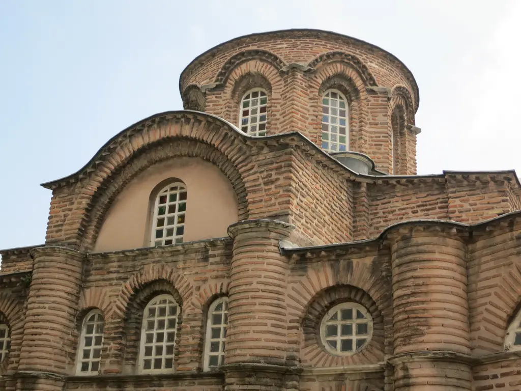 Bodrum Camii'nin kubbe kasnağı alttan yakın planda; kemerli uzun pencereler, altında haç kolunun büyük kemeri ile sıvalı alınlığı ve yuvarlak madalyon pencere.