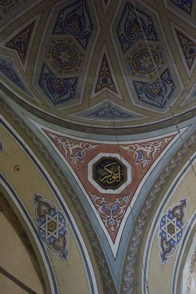 Gül Camii'nde bir pandantif; siyah zeminli sekizgen madalyonda altın yazı, çevresinde gül kurusu rumi bezeme, kemer karınlarında altı köşeli yıldızlar.