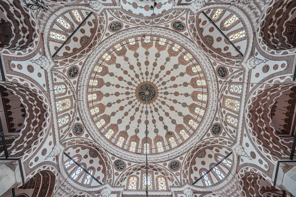 Yeni Valide Camii'nin kubbesi; kahverengi ve beyaz kalem işi desenler, pencereler ve köşe kubbeleri.