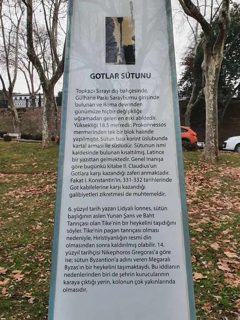 Gotlar Sütunu'nun yanındaki bilgi levhası; beyaz zemin üzerinde Türkçe metin, üstte sütunun küçük bir resmi, arkada ağaçlar.