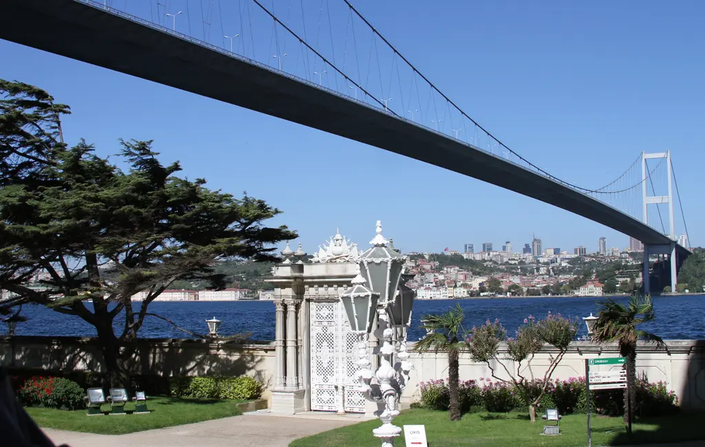 Beylerbeyi Sarayı'nın bahçesi; büyük sedir ağacı, deniz köşkü, fenerli bahçe ve üstte uzanan köprü ile karşı kıyı.
