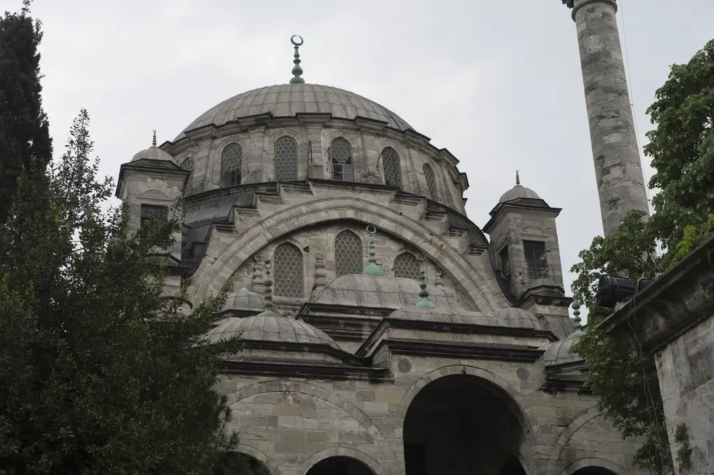 Ayazma Camii; kurşun kubbe, yarım kubbeler, köşe kuleleri, tek şerefeli minare ve yanda ağaç dalları.