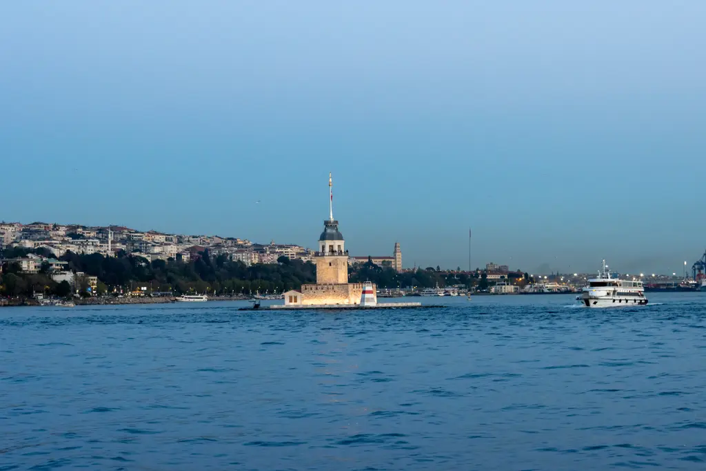 Denizden Kız Kulesi; mavi Boğaz suyu, ortada adacık üzerindeki kule, arkada Üsküdar'ın yamaçlara yayılan binaları.