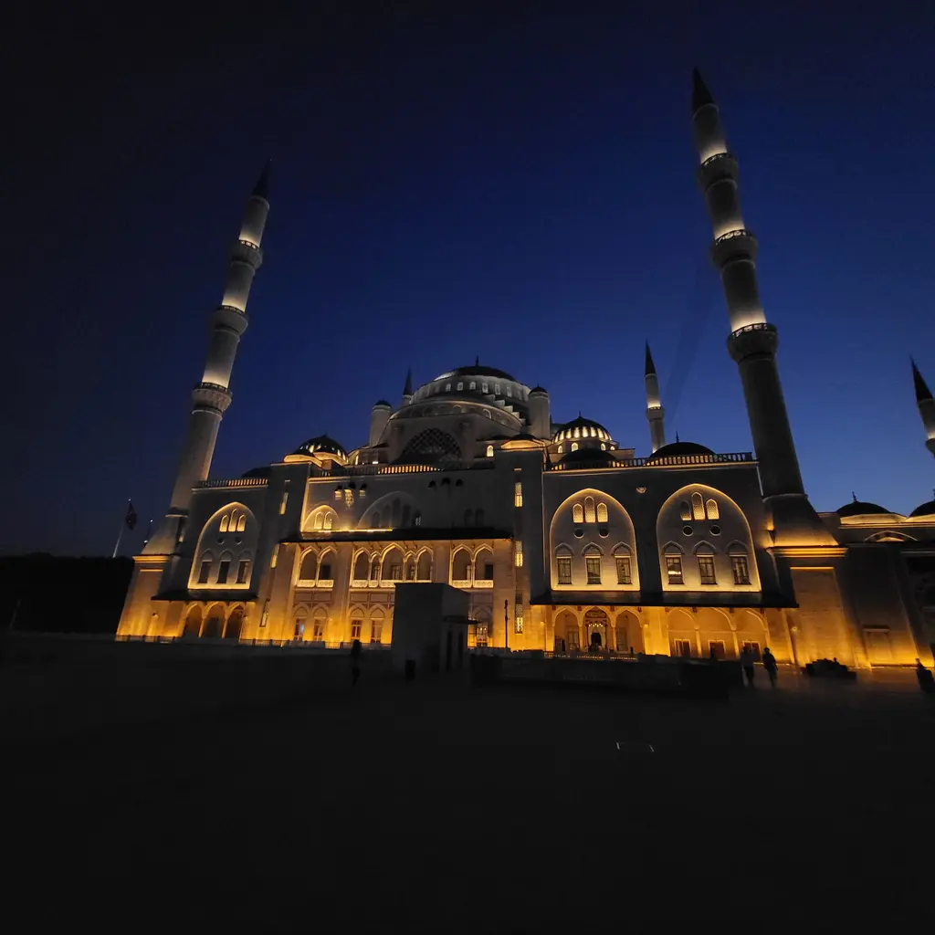 Gece Büyük Çamlıca Camii; lacivert gökyüzü altında ışıklandırılmış kubbeler, cephe ve minareler.